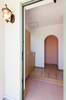 ドアを開けると広々とした玄関の奥にオレンジ色が特徴的なアールの出入り口。